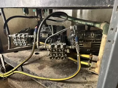 Old multi-pump pressure washer setup showing worn pumps and motors prior to repair work at a malt house in Burton.